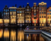 Damrak Dancing Houses Amsterdam A night view of the Damrak in Amsterdam with old buildings.