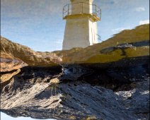 Laukvik Lighthouse The lighthouse in Laukvik, Lofoten, Norway, reflecting in a small puddle.