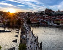 Sunset over the Charles Bridge in Prague Sunset view over the old town of Prague with a view over the Charles Bridge to the Prague Castle. Lot's of tourists are.walking over the bridge.